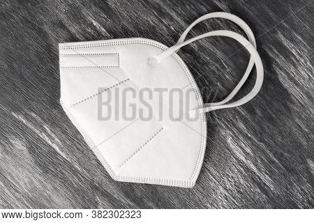 One Medical Protective Mask Kn-95 On An Artistic Wooden Background. Preventing Covid-19 Infection