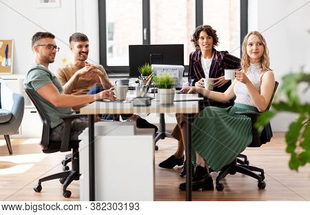 business, people and corporate concept - team of startuppers drinking coffee at office