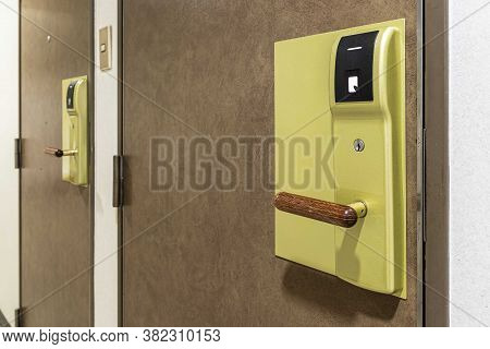 Close - Up Key Card Door Opener On Brown Wood Door