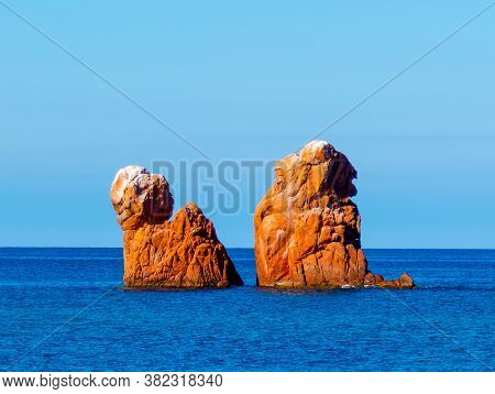 Orange Sea Stacks And Blue Sea In Cea Beach On A Clear Day. Sardinia, Italy