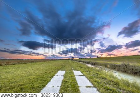 Trail In Agricultural Open Grassy Countryside At Sunset Under Beautiful Sky. Usquert, Groningen, Net