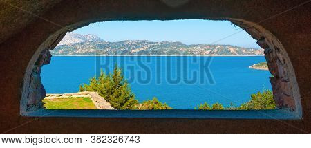 Capo Coda Cavallo Shore Seen Through A Rustic Arch. Sardinia, Italy