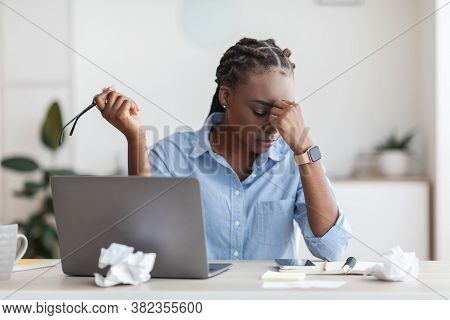 Deadline Stress. Overworked Black Female Entrepreneur Massaging Nosebridge At Workplace In Office, E