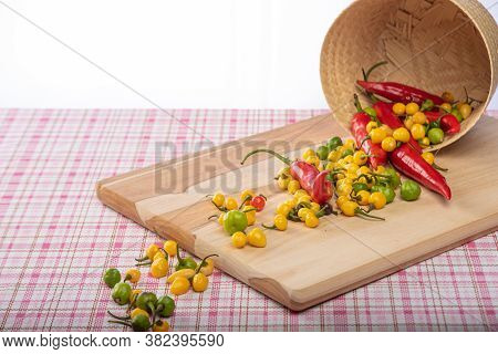 Colored Peppers Fallen From A Basket On A Table, Selective Focus.