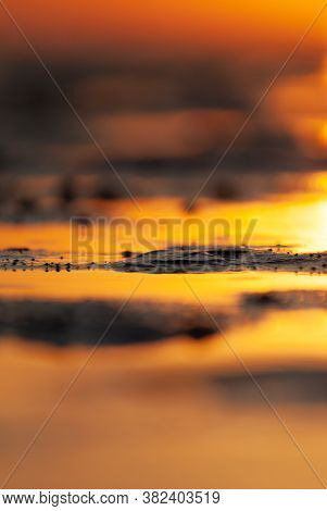 Puddles In The Mudflap At Low Tide In The Light Of A Sunset.