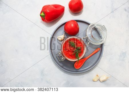 Ajvar (pepper Mousse) In A Jar And On Gray Plate And Gray Backgground. Ajvar - Delicious Dish Of Red