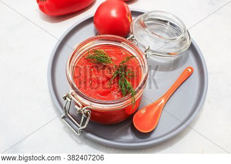 Ajvar (pepper Mousse) In A Jar And On Gray Plate And Gray Backgground. Ajvar - Delicious Dish Of Red