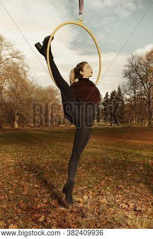 Nice Lady Posing In Autumn Park And Exercising With Steel Hoop