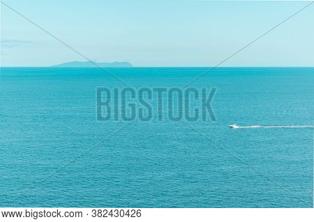 Blue Clear Sky And Turquoise Sea Landscape. A Boat Floats In The Distance. Summer Sea Bay. Vladivost