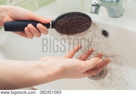 Females Hands Clean A Comb Over The Sink From A Bunch Of Torn Hair. Hands Close-up. The Concept Of B