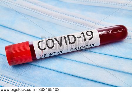 Conceptual Photo. Blood Test Samples For Presence Of Coronavirus On The Face Protective Madical Mask