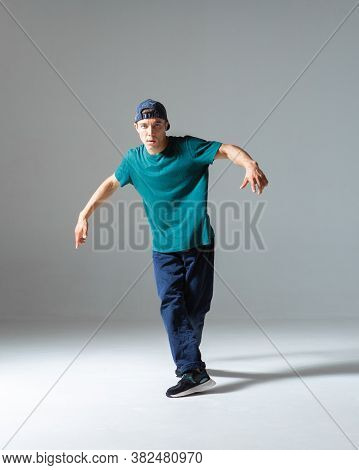 Cool Guy Breakdancer Dancing In Studio Isolated On Gray Background. Breakdance Lessons