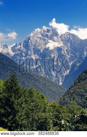 Alpine Mountain Peak Veliki Ozebnik With Few Clouds Surrounded By Hills Of Coniferous Forests. Mount