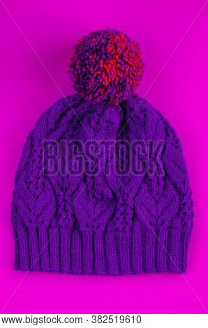 Beautiful Kace Handknitted Hat With Multicolored Pompon On Pink Background. Top View