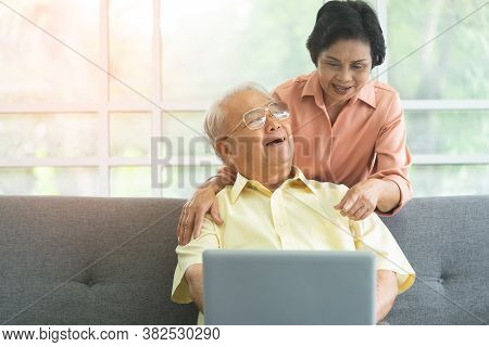 Happy Senior Couple Is Using Laptop For Technology Entertainment And Communication On Internet.