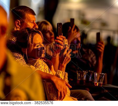 Odessa, Ukraine - Cirka 2020: Spectators At Concert In Theater Take Pictures Of Performance Of Their