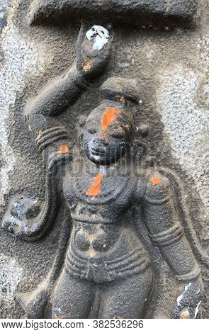 Sculpture Of God Krishna Holding The Mountain. Bas Relief Sculpture Carved In The Stone Wall Of Shiv