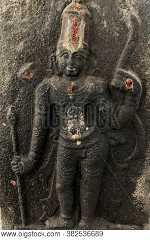 Hindu God With Javelin In Hand Sculpture. Bas Relief Sculpture Carved In The Stone Walls Of Shiva Te