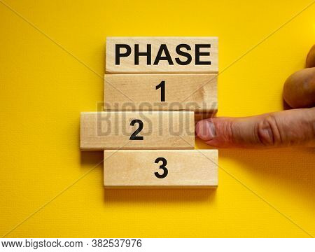 Time To Phase 2. Wooden Blocks Form The Words 'phase, 1, 2, 3,' On Yellow Background. Male Hand. Bea
