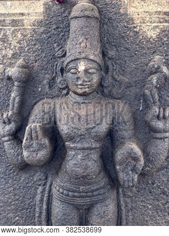 Hindu God Sculpture With Four Hands. Bas Relief Sculpture Carved In The Stone Wall Of Shiva Temple, 