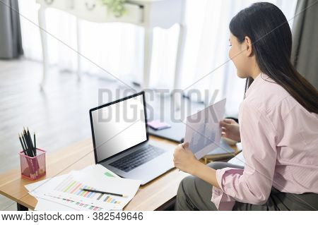 A Business Woman Is Working With Laptop Mock Up Screen, Analyzing Business Plan In Home Office.