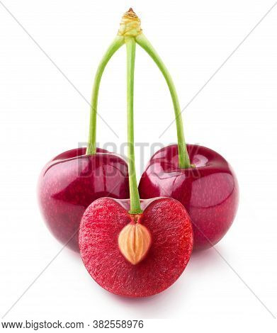 Isolated Cherries. Three Sweet Cherry Fruits On One Stem, One Cut In Half With A Pit, Isolated On Wh
