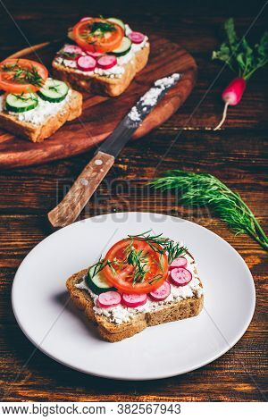 Vegetarian Sandwich With Fresh Sliced Tomatoes, Cucumber And Radish On White Plate