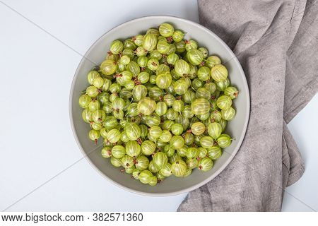 Ripe Green Gooseberry Berry In Plate Bowl. Green Gooseberry On Light Blue Background. Top View
