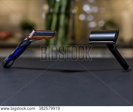 Two Razors Opposite Each Other On A Black Floor