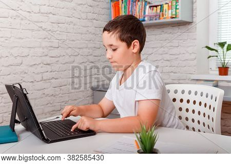 Toddler Boy Doing Her Homework With Laptop At Home. Preteen Schoolboyl Using Gadgets To Study. Educa