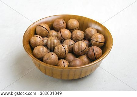 Natural Organic Macadamia Nuts In Wooden Bowl On Gray Concrete Background Flat Lay Top View Healthy 