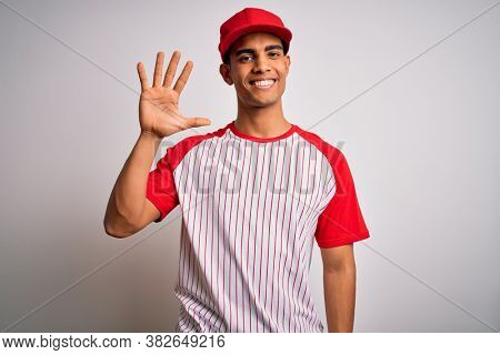 Young handsome african american sportsman wearing striped baseball t-shirt and cap showing and pointing up with fingers number five while smiling confident and happy.
