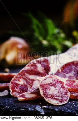 Jerked Italian Salami With Rosemary, Spices, Olives And Oil. Dark Vintage Background, Low Key, Selec
