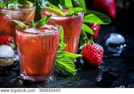 Alcoholic Cocktail Strawberry Mojito With White Rum, Syrup, Soda, Lime, Mint And Ice, Black Backgrou