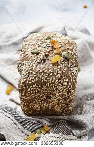 Whole Wheat Organic Rye Dark Bread With Pumpkin Seeds, Dried Fruit, Raisins And Sesame Seeds On Gray