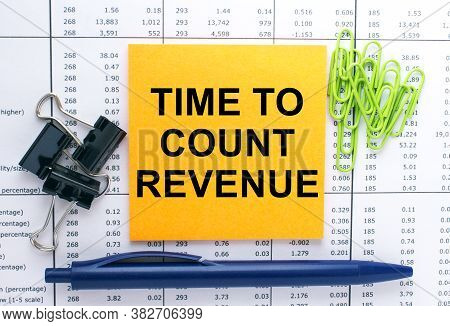 Text Time To Count Revenue On Financial Tables With Pen And Paper Clips