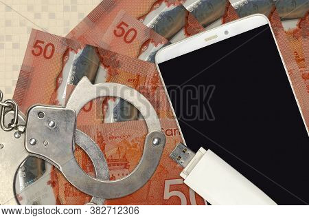 50 Canadian Dollars Bills And Smartphone With Police Handcuffs. Concept Of Hackers Phishing Attacks,