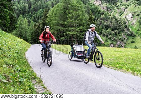 Family With E Bike Mtb And Kid Trailer Training