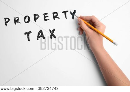 Woman Writing Phrase Property Tax On White Background, Closeup