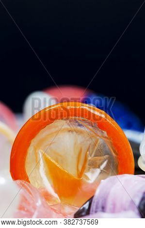A Whole Orange Latex Condom, A Means To Prevent Pregnancy And Infection, Close-up And Small Depth Of