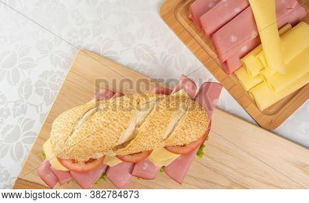 Mortadella Sandwich, Lettuce, Tomato And Cheese On A Polished Board And Slices Of Mortadella And Che