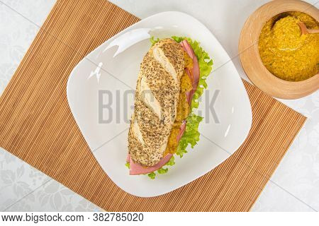 Mortadella And Lettuce Sandwich With Oregano-covered Bread, On A White Plate And A Bamboo Mat And Pe