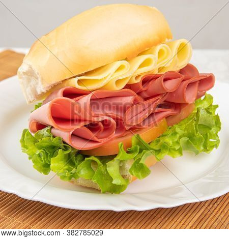 Mortadella Sandwich, Lettuce And Cheese On A White Plate And A Bamboo Mat With White Background On A