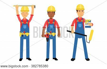Young Man Constructor In Yellow Hard Hat And Blue Overall Holding Paint Roller And Measurement Tool 