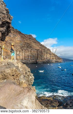A Young Tourist In Summer From The Viewpoint Looking And Enjoying The Cove Of Puerto De Puntagorda, 