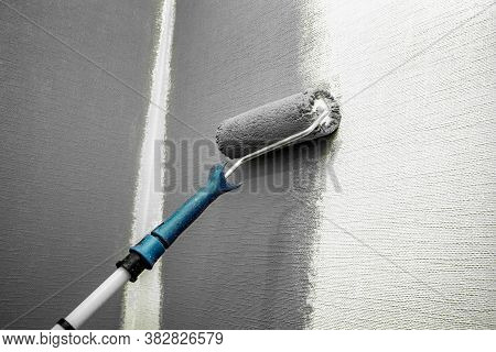 Close Up Roller With Gray Paint For Painting Walls. Repairs. White Wall. Background. Screensaver For