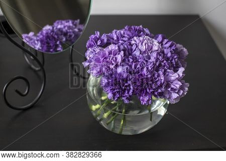 Bridal Bouquet Of Lilac Carnations In A Round Glass Vase As Table Decoration