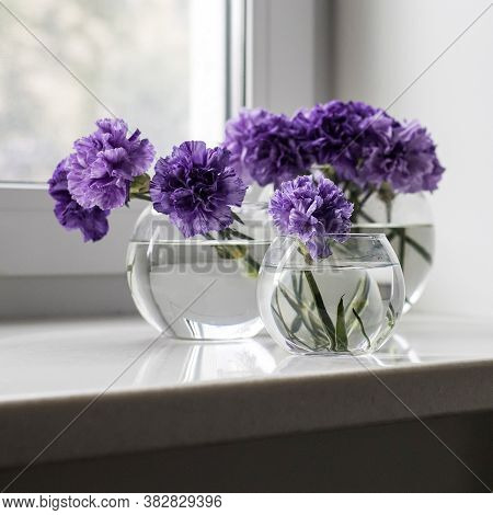 Bridal Bouquet Of Lilac Carnations In A Round Glass Vase