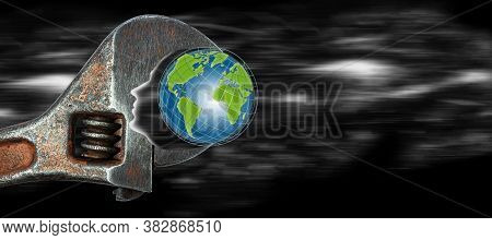 An Adjustable Wrench With A Globe Clamped In It. Human Silhouette As A Symbol Of The Impact On The E