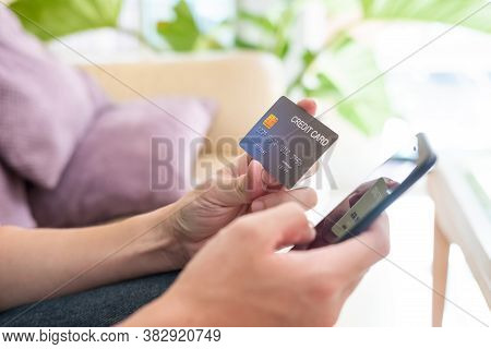 Selective Focus Shot At Credit Card Mock Up. Asian Men Hand Holding Credit Card While Type Informati
